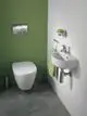 Handtuchring in Chromfarbe, montiert an einer Wand mit grüner Fläche. Links befindet sich eine weiße Toilette. Teil des Designs von Ideal Standard in einem modernen Badezimmer.